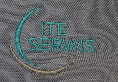 Turkusowy haft komputerowy logo ITE Serwis na szarej tkaninie