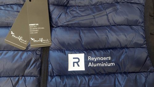 Granatowa pikowana kamizelka z logo Reynaers Aluminium wykonanym folią flex