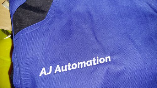 Granatowa odzież robocza z logo AJ Automation – detal